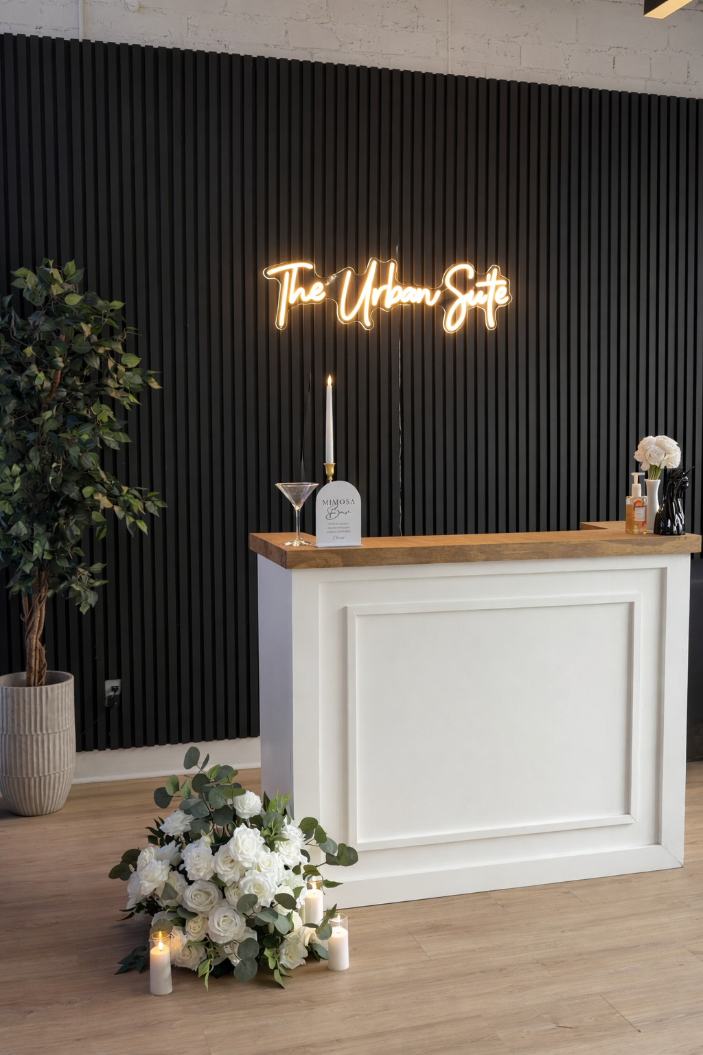 The bar area at The Urban Suite with a glowing neon sign above it