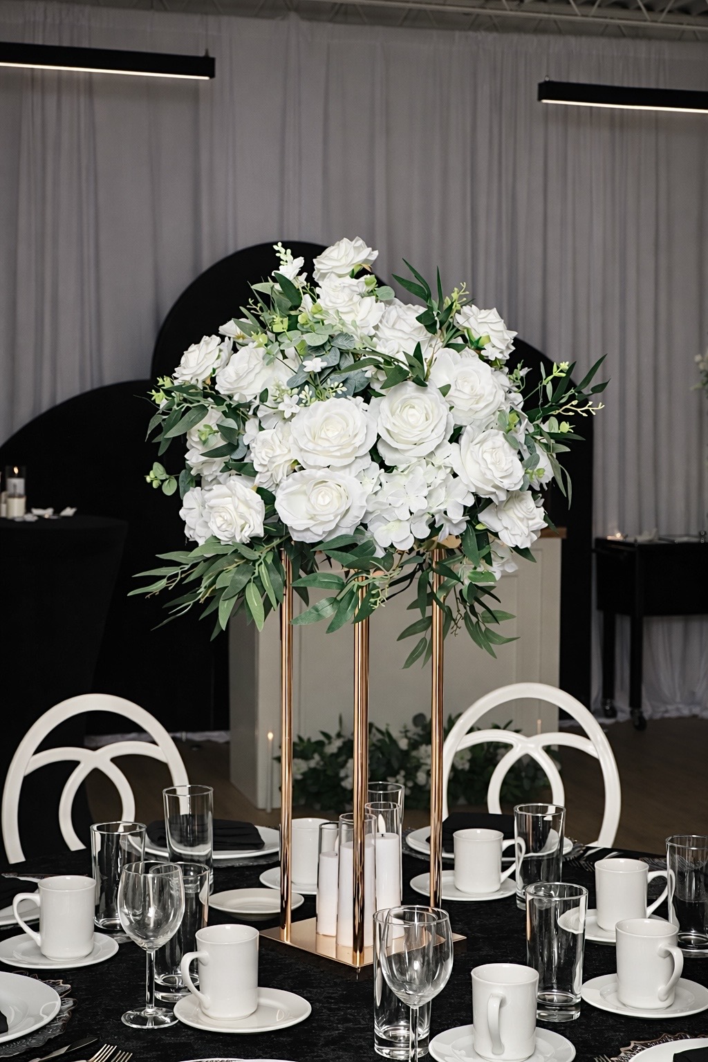 Tall white floral arrangement on a styled table
